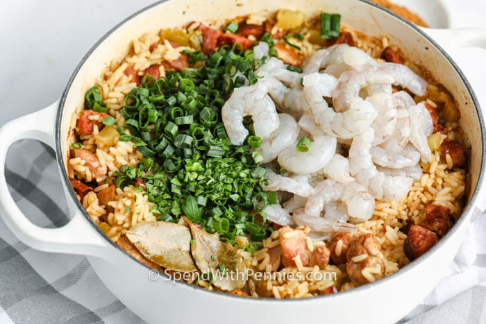 adding shrimp and green onions to Cajun Jambalaya