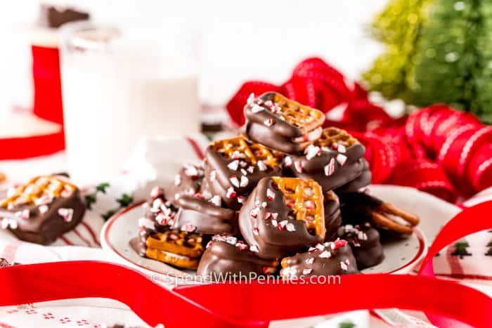 Peppermint Bark Pretzel Bites with ribbon and a glass of milk in the back