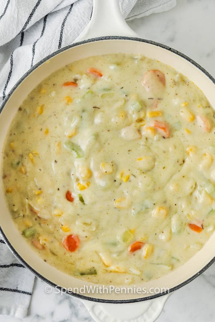 Homemade chicken pot pie is an old fashioned favorite that delivers pure comfort in every bite. This creamy, hearty dish is loaded with juicy chicken, colorful vegetables, and baked in the flakiest crust. Use rotisserie chicken or leftovers for a quick prep, or make it from scratch for the best flavor. It freezes beautifully, and doubling the ingredients and baking it as a casserole means extra servings for tomorrow. #spendwithpennies Chicken Pot Pie vegetable filling in a pot to make a Chicken Pot Pie