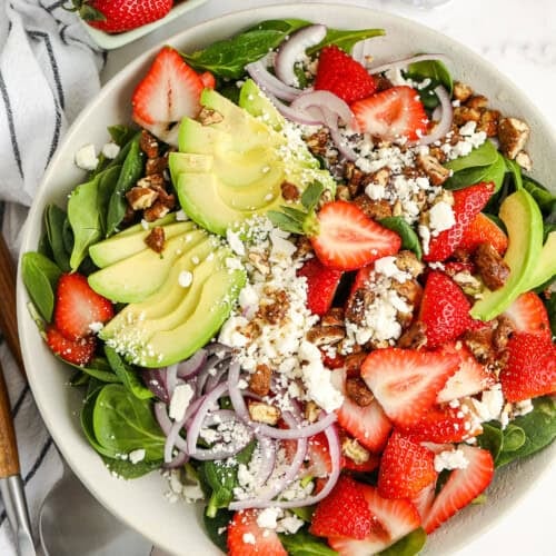 strawberry spinach salad with avocado in a bowl