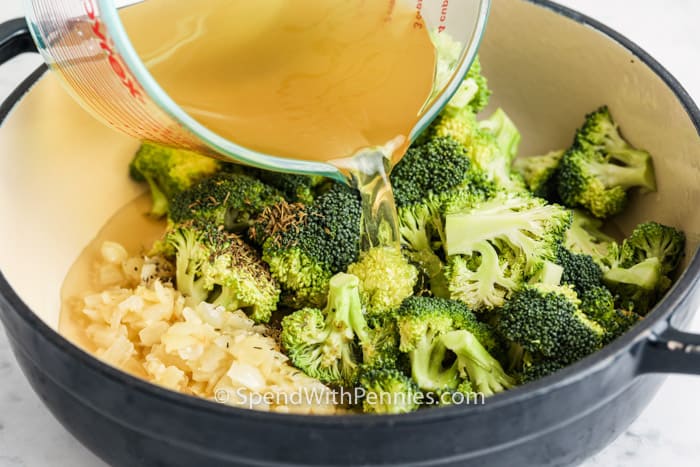 pouring broth into pan to make Broccoli Cheddar Soup