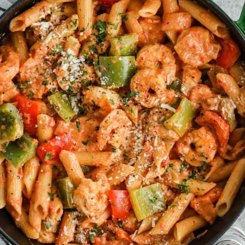 A Dutch oven of cajun shrimp pasta with cheese on top