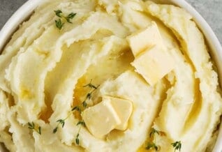A bowl of mashed potatoes with butter