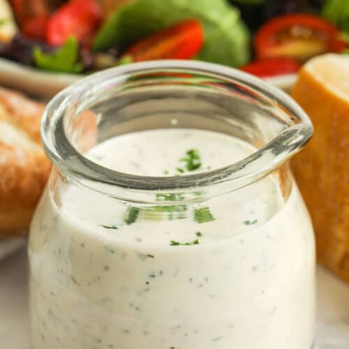 jar of Creamy Italian Dressing with salad in the back