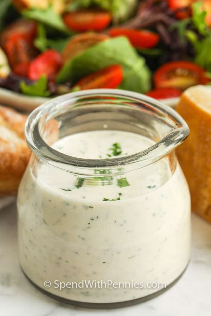 jar of Creamy Italian Dressing with salad in the back