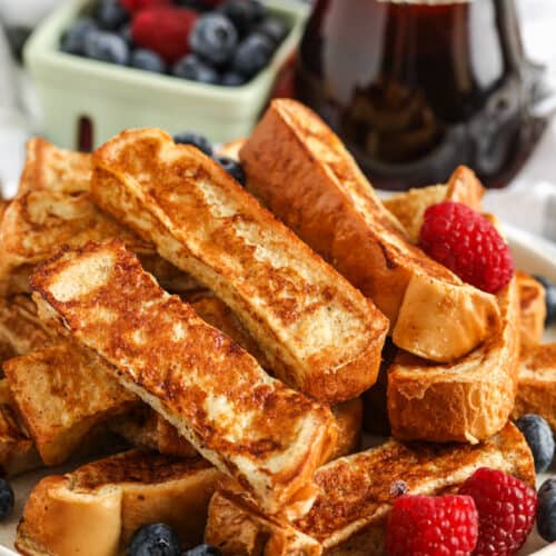 French Toast Sticks with syrup and berries in the back