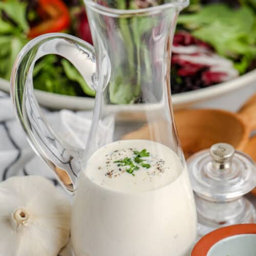 Creamy Garlic Dressing with salad in the background