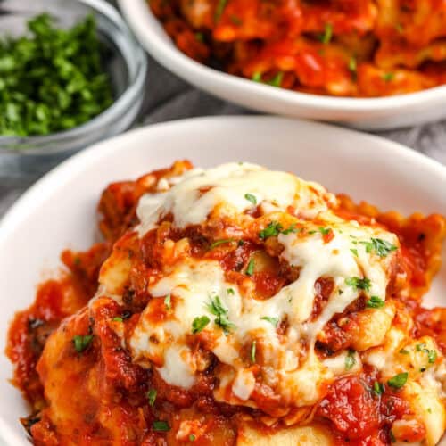 ravioli in a bowl topped with cheese and parsley