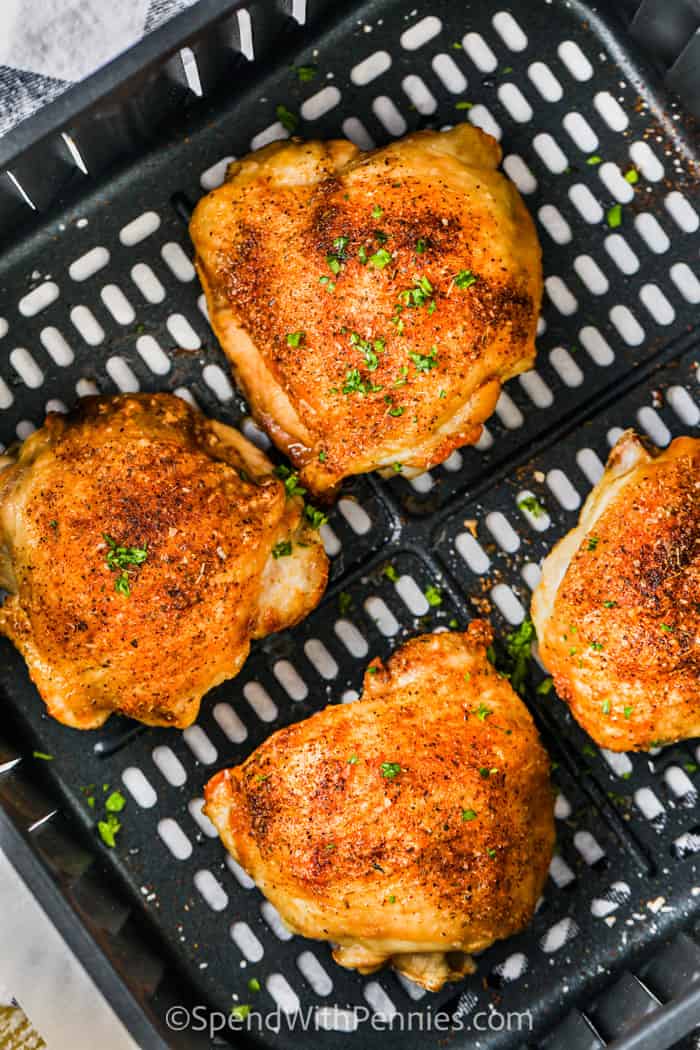 Make delicious air fryer chicken thighs effortlessly, and they'll be juicy and tender. Whether you choose bone-in or boneless skinless thighs, this simple recipe is a winner. With minimal ingredients and a homemade seasoning mix, enjoy flavorful chicken with less oil and less mess! #spendwithpennies #airfryerchickenthighs #chickenthighsintheairfryer #boneinchickenthighsairfryerrecipe cooked Air Fryer Chicken Thighs in the air fryer