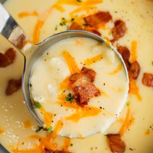 Cauliflower Cheddar Soup in the pot with a paddle full