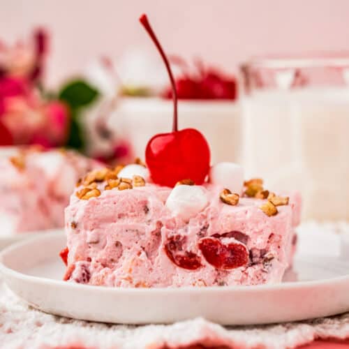 close up of Frozen Cherry Fluff Salad on a plate with a cherry