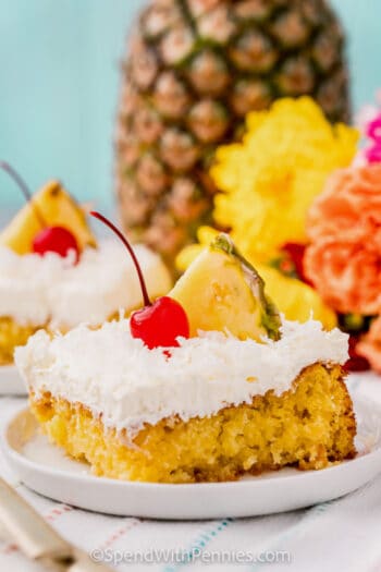 plated Pina Colada Cake with a cherry and pineapple on top