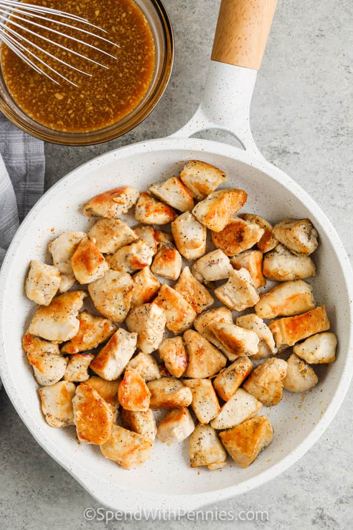 bovenaanzicht van gekookte kip en saus om Honey Garlic Chicken te maken