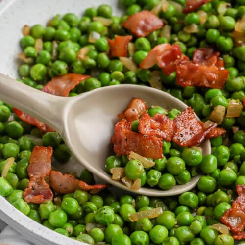 spoon scooping Green Peas with Bacon