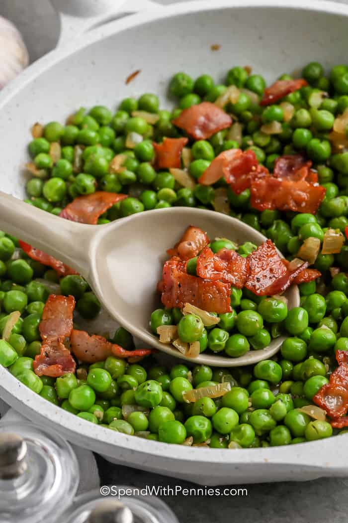 spoon scooping Green Peas with Bacon