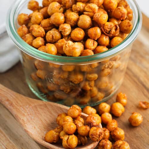 jar of Spiced Air Fryer Chick Peas with a wooden spoon beside it