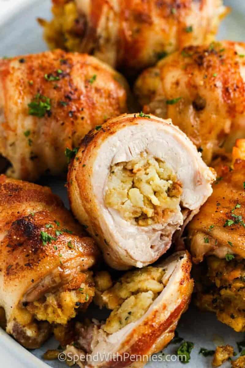 Stuffed chicken thighs wrapped in bacon are the ultimate entree. Savory & filling, these crispy thighs are oven-baked to perfection! #spendwithpennies #stuffedchickenthighs #entree #recipe #stuffed #wrapped #bacon #bake #long #oven #baked a close up of a stuffed chicken thigh