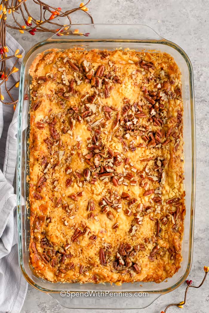 Put some sweet crunch into fall baking with this delicious pumpkin crunch cake recipe. The base pumpkin layer is sprinkled with cake mix, pecans, and a streusel topping! #pumpkincrunchcake #cake #dessert #spendwithpennies cooked Pumpkin Crunch Cake in a baking dish