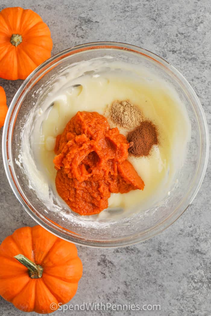 Pumpkin dip is the easy recipe you need for fall gatherings and cozy snacks. Pumpkin puree, warm spices, and cream cheese mix together for a rich base, while whipped topping adds a fluffy, cool finish. Serve it with apples, graham crackers, or cookies and watch it disappear fast. It has the flavor of pumpkin pie cheesecake but in a light, creamy pudding dip form, making it both festive and simple to enjoy any time. #spendwithpennies ingredients in a bowl to make Fluffy Pumpkin Dip