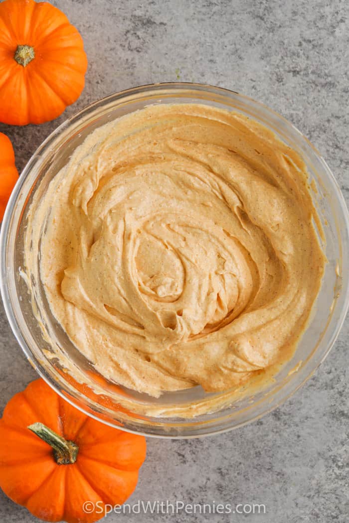 Pumpkin dip is the perfect fall fluff recipe for anyone who loves pumpkin pie. A base of cream cheese is blended with pumpkin puree and spice, then finished with whipped topping for a cool and creamy texture. This dip is sweet, smooth, and perfect for dunking fruit or cookies. The taste is like cheesecake and pudding rolled into one, making it a family favorite. Bring it to parties or keep it at home for a quick seasonal treat. #spendwithpennies Fluffy Pumpkin Dip mixed in a glass bowl