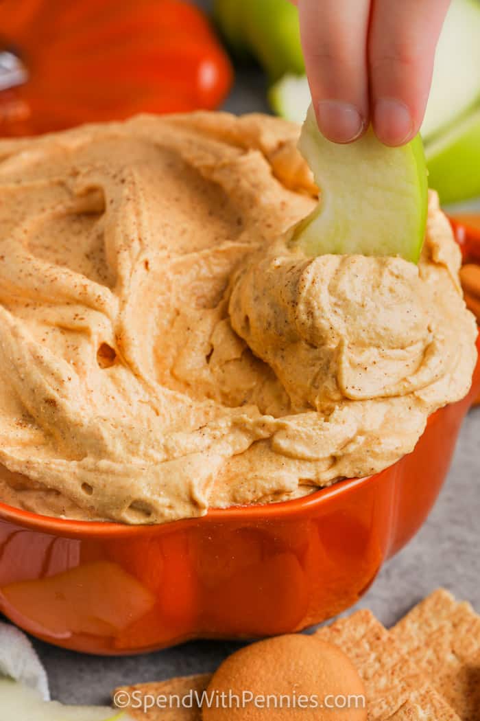 dipping an apple in Fluffy Pumpkin Dip