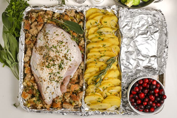 uncooked turkey breast and potatoes on a sheet pan