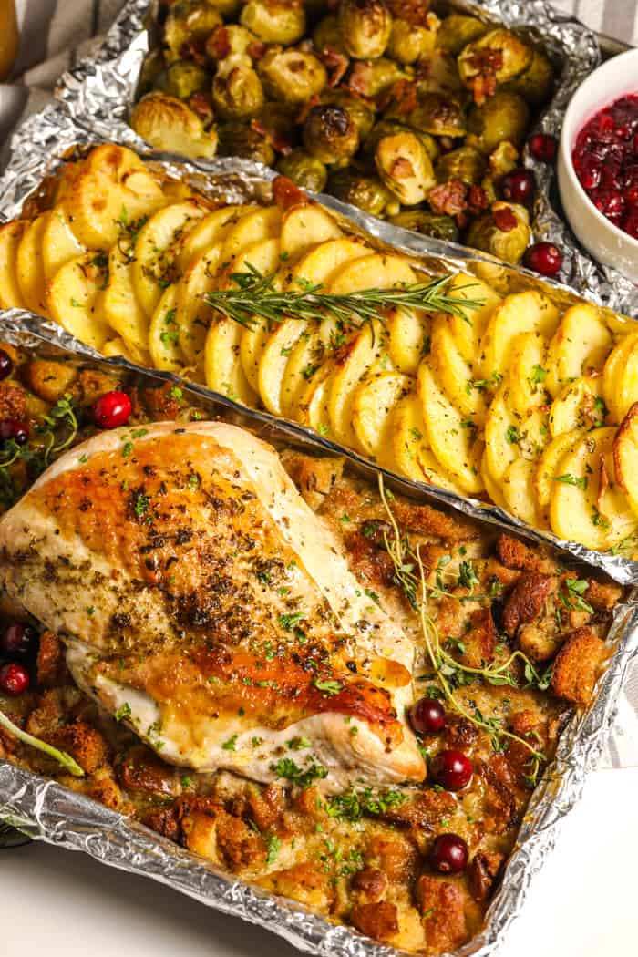 a turkey dinner on a sheet pan topped with fresh herbs