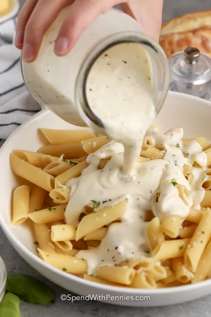 pouring Cream Cheese Pasta Sauce over pasta
