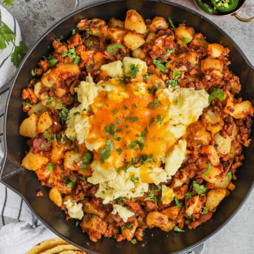 Chorizo Hash cooked in the pan with bowls of ingredients around it