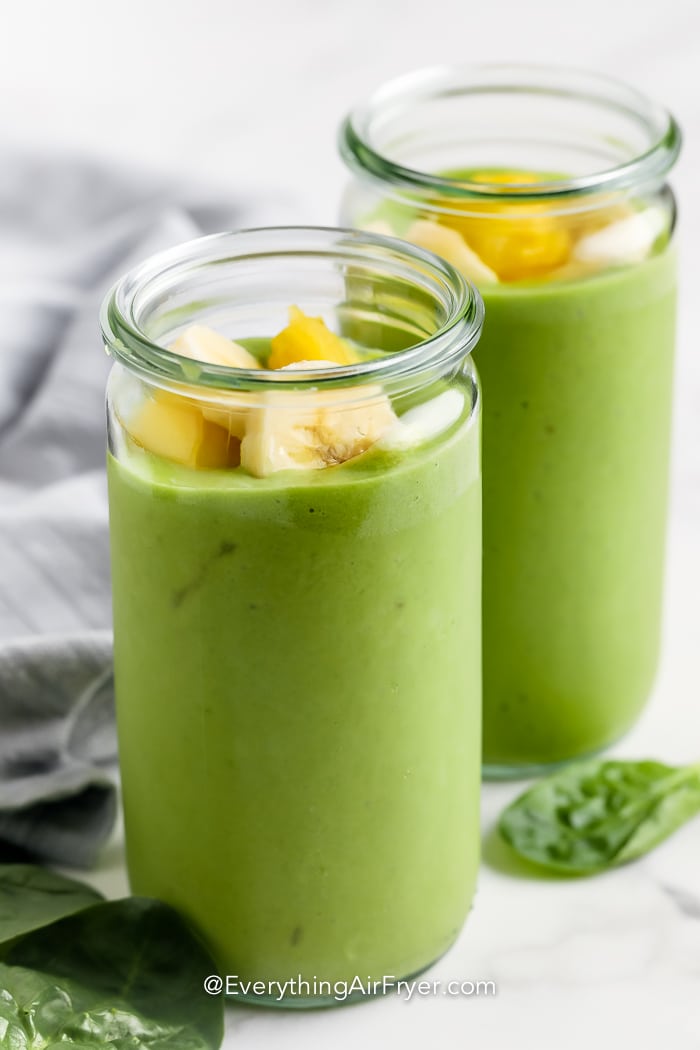 pineapple and banana on a green smoothie in a glass