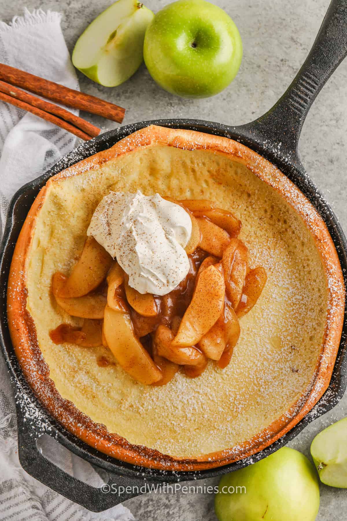 Apple Dutch Baby in a pan with whipped cream