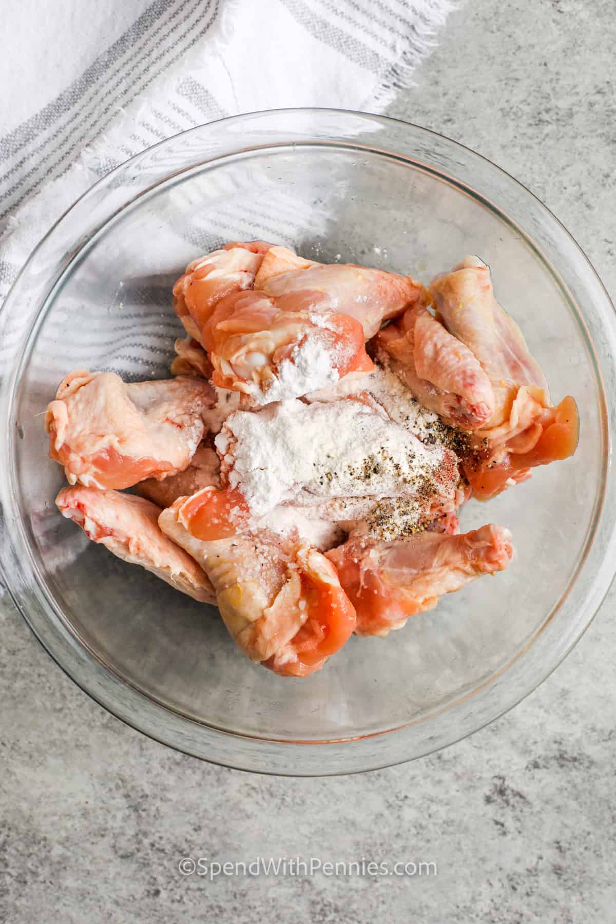 adding seasonings to chicken to make Garlic Parmesan Wings