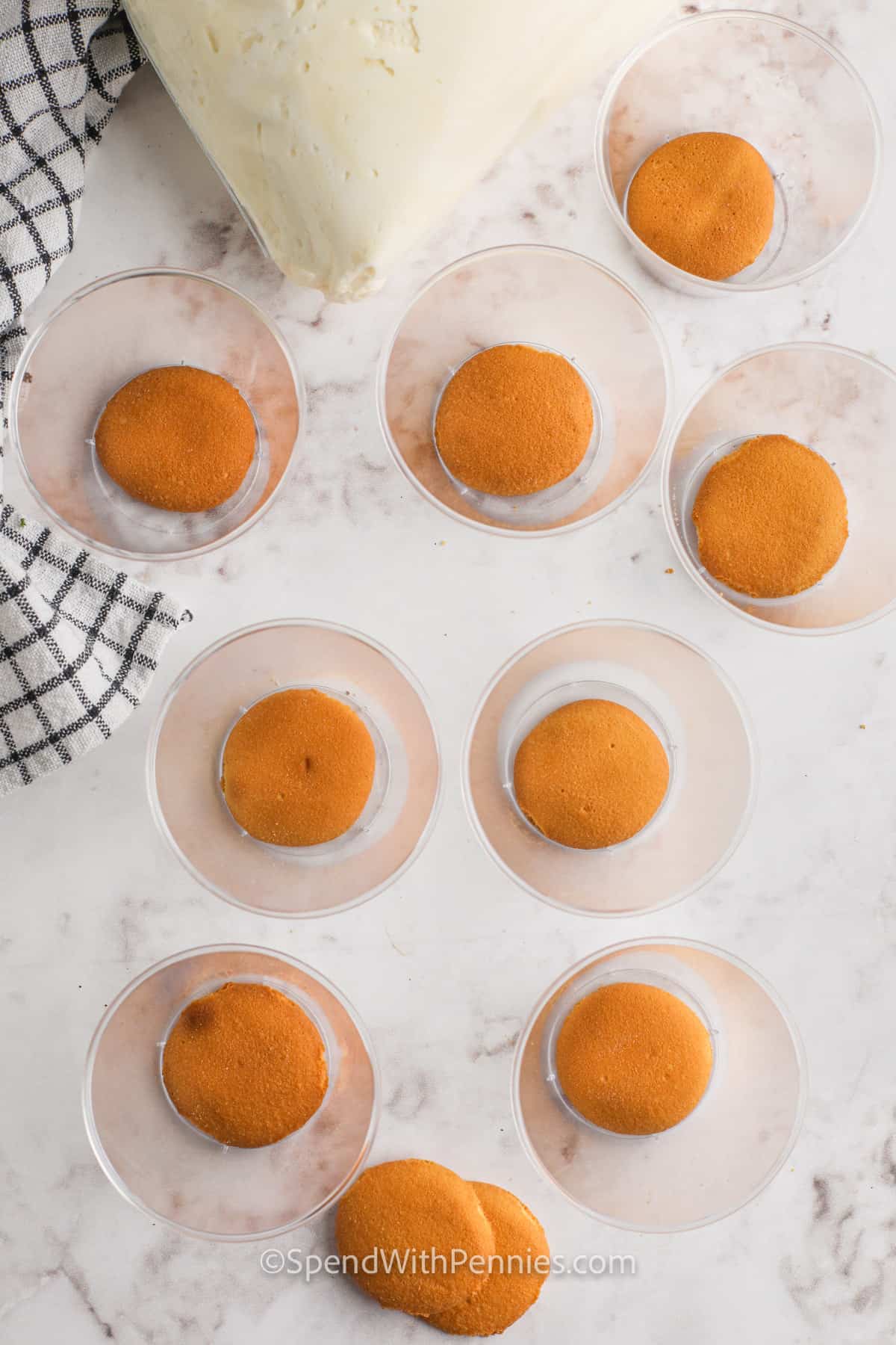 adding cookies to cups to make No Bake Cheesecake Cups