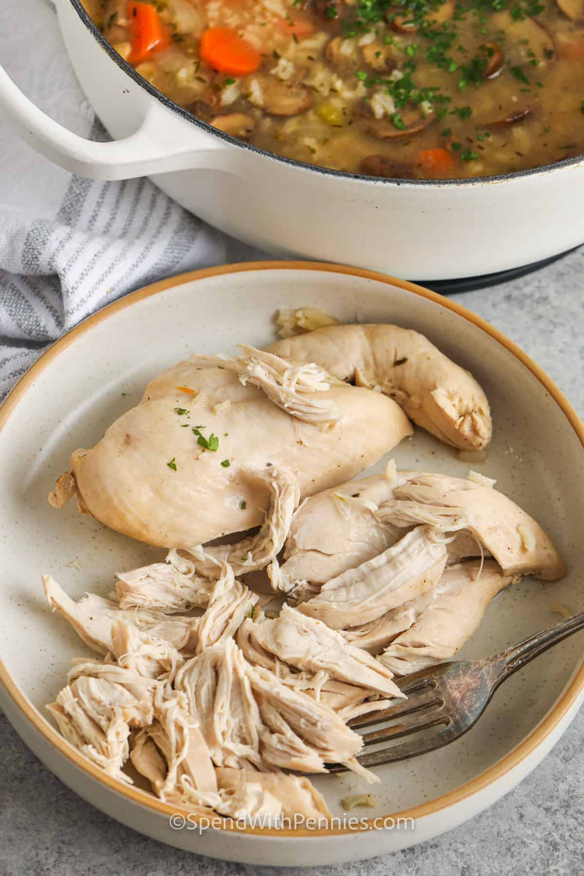 Chicken and mushroom soup is a simple homemade soup filled with earthy mushrooms, tender chicken, soft rice, and classic vegetables. The stovetop method keeps it easy, and the broth becomes rich and savory as everything simmers together. This is a great recipe for cold days, meal prep, or using up everyday ingredients in a cozy way. Add fresh parsley at the end for a little color and brightness. #spendwithpennies shredding chicken to make Chicken Mushroom Soup