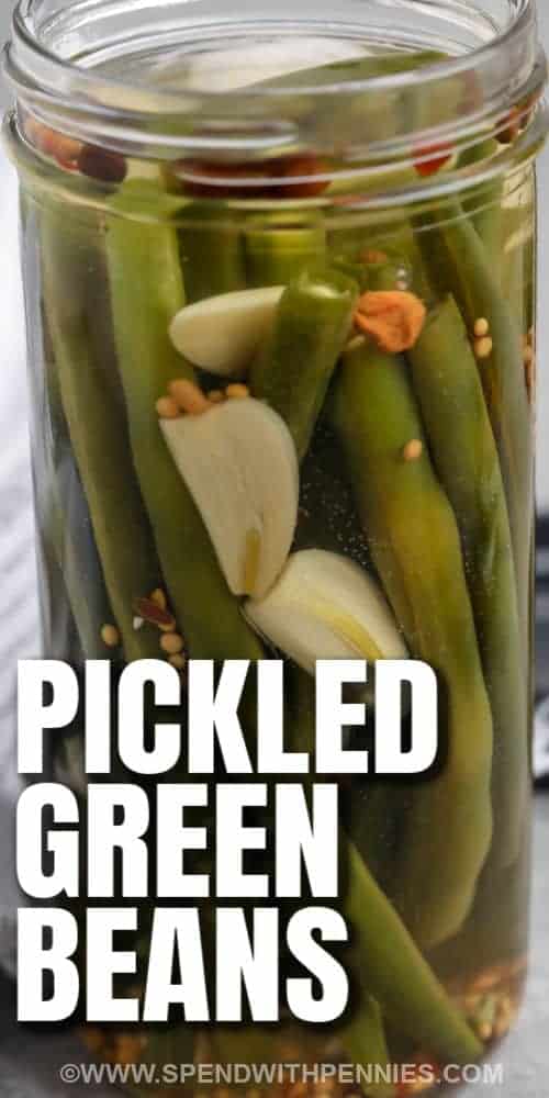 The pickled green beans in this recipe are a perfect side dish or garnish. Made with just a few simple ingredients like garlic, vinegar, pickling spices, and some dill, they are so flavorful. No complicated canning is required, just store in the refrigerator for the best quick and crunchy pickled vegetables ever. #pickledgreenbeans #spendwithpennies #nocanning #howto finished Quick Pickled Green beans in the jar with writing
