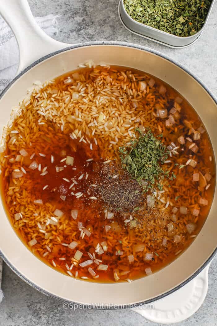 All ingredients to make seasoned rice in a sauce pan