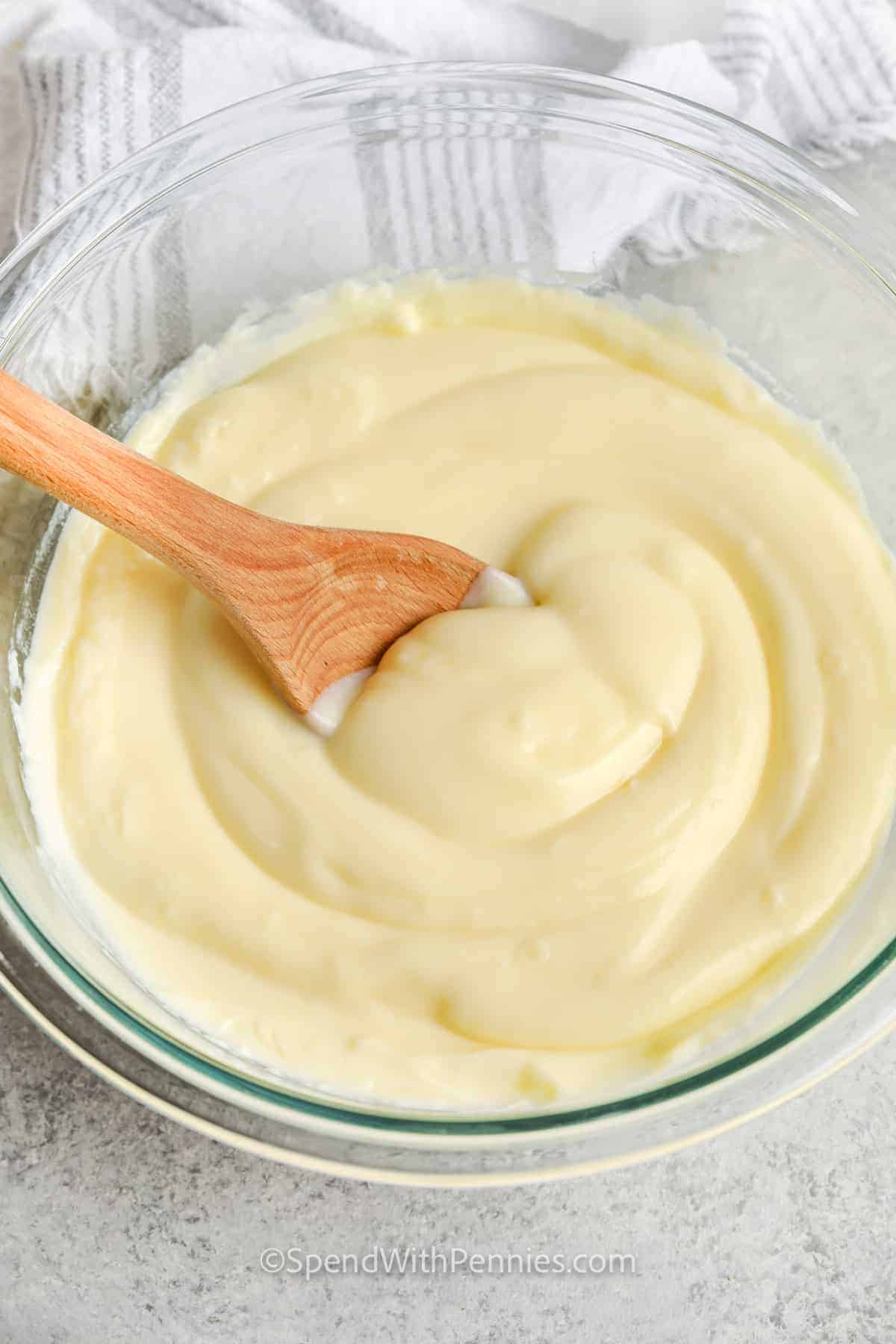 Make this deliciously sweet and creamy Vanilla Custard recipe and use it on its own or in dessert recipes that call for pudding or a creamy filling. It goes perfectly with pies, tarts, and even homemade ice cream. The best part? Making vanilla custard from scratch is a piece of cake, and it's ready in no time. #vanillacustard #recipe #homemade #spendwithpennies Vanilla Custard in a bowl with a spoon