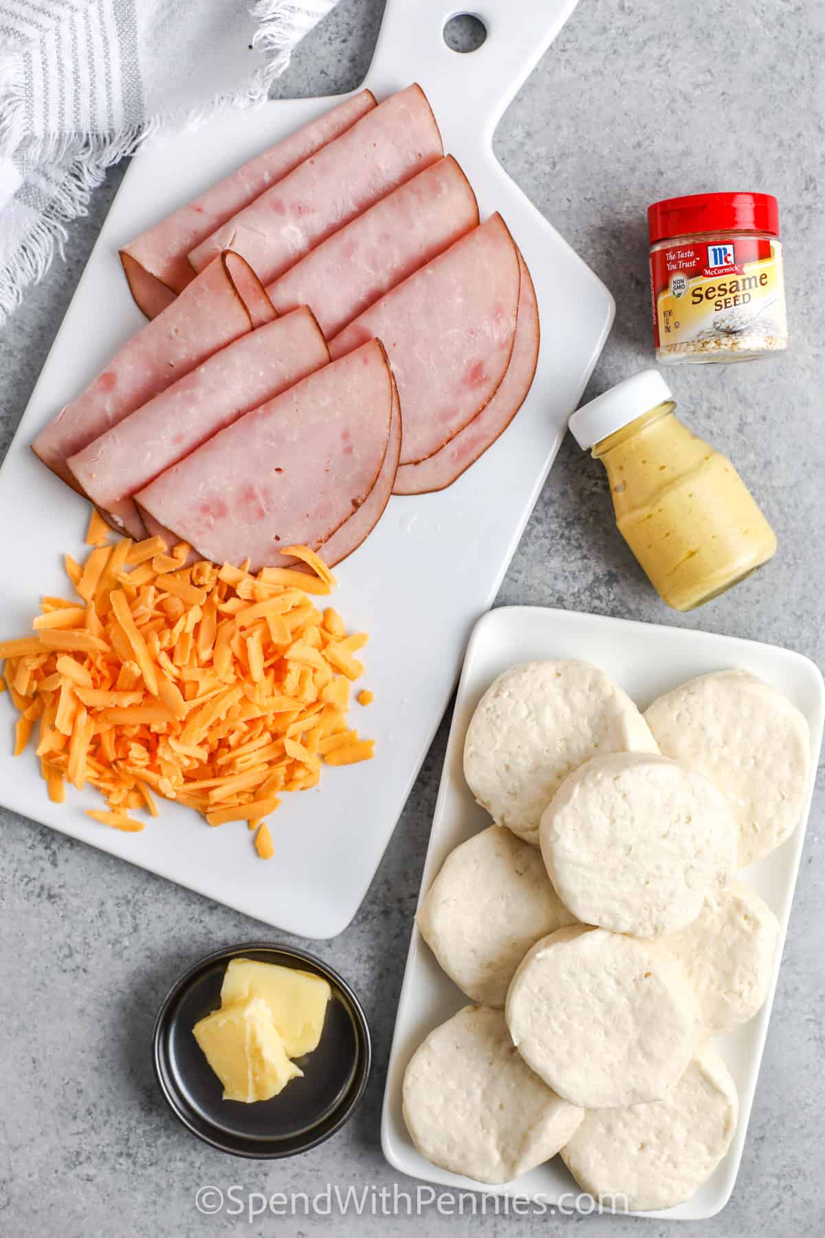 These ham and cheese stuffed biscuits are the best for breakfast or lunch. Pillsbury dough makes these biscuits a cinch to make. Just add the ham and cheese, and cook. Top with gravy and these are sure to be devoured. #hamandcheesestuffedbiscuits #stuffedbiscuits #biscuits #spendwithpennies ingredients to make Stuffed Biscuits