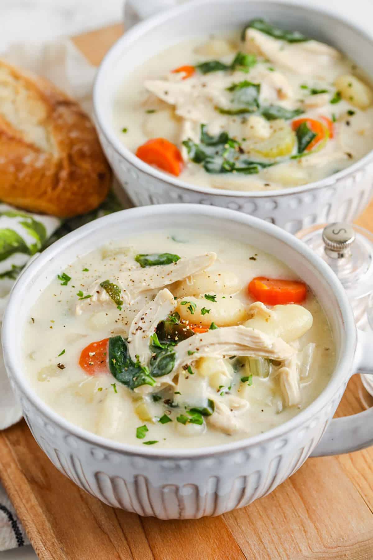 Chicken Gnocchi Soup is the tastiest copycat recipe ever. Who needs to go out to a restaurant when you can make homemade chicken gnocchi soup right at home? Stovetop, Crockpot, or even the Instant Pot can be used to make this creamy Gnocchi soup. #spendwithpennies #chickengnocchisoup #soup #recipe Chicken Gnocchi Soup in bowls