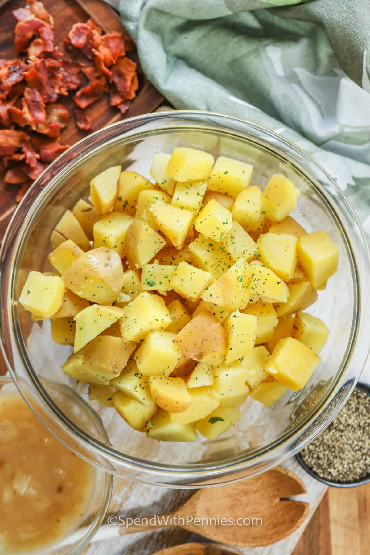 This authentic German potato salad is a delicious departure from American-style potato salad. In this recipe, potatoes are tossed with a tangy vinaigrette, bacon bits, and some celery. Serve it hot or cold for an incredible side dish. #germanpotatosalad #germanpotatosaladrecipe #coldgermanpotatosalad #spendwithpennies ingredients to make German Potato Salad