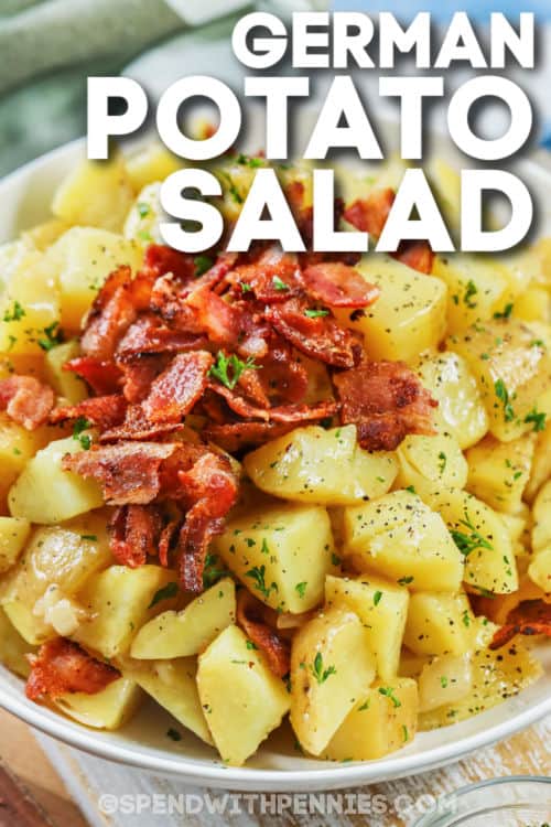 This German potato salad is an authentic recipe that is sure to get rave reviews. It is so easy to cook this salad in advance and have it ready to bring to the next gathering! Whether it is served hot or cold, it will still taste tangy and delicious. #germanpotatosalad #germanpotatosaladrecipe #coldgermanpotatosalad #spendwithpennies German Potato Salad on a plate with a title