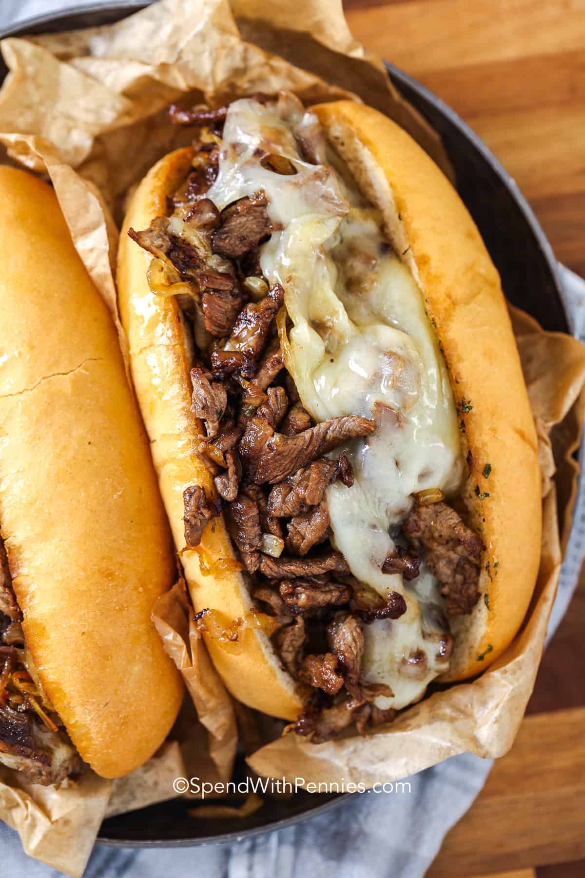 philly cheesesteak topped with cheese in a bun