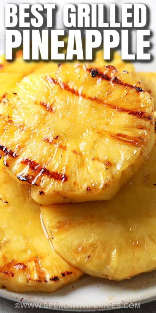 Add a splash of color and sweetness to almost any recipe with this grilled pineapple. Cooked to a caramelized perfection on the grill, this pineapple is so good for adding to kabobs or serving as a side dish with some chicken or seafood. Serve it for a simple dessert or add it to sundaes. #grilledpineapple #grilledpineapplerecipe #howtogrillapineapple #spendwithpennies close up of Grilled Pineapple with a title