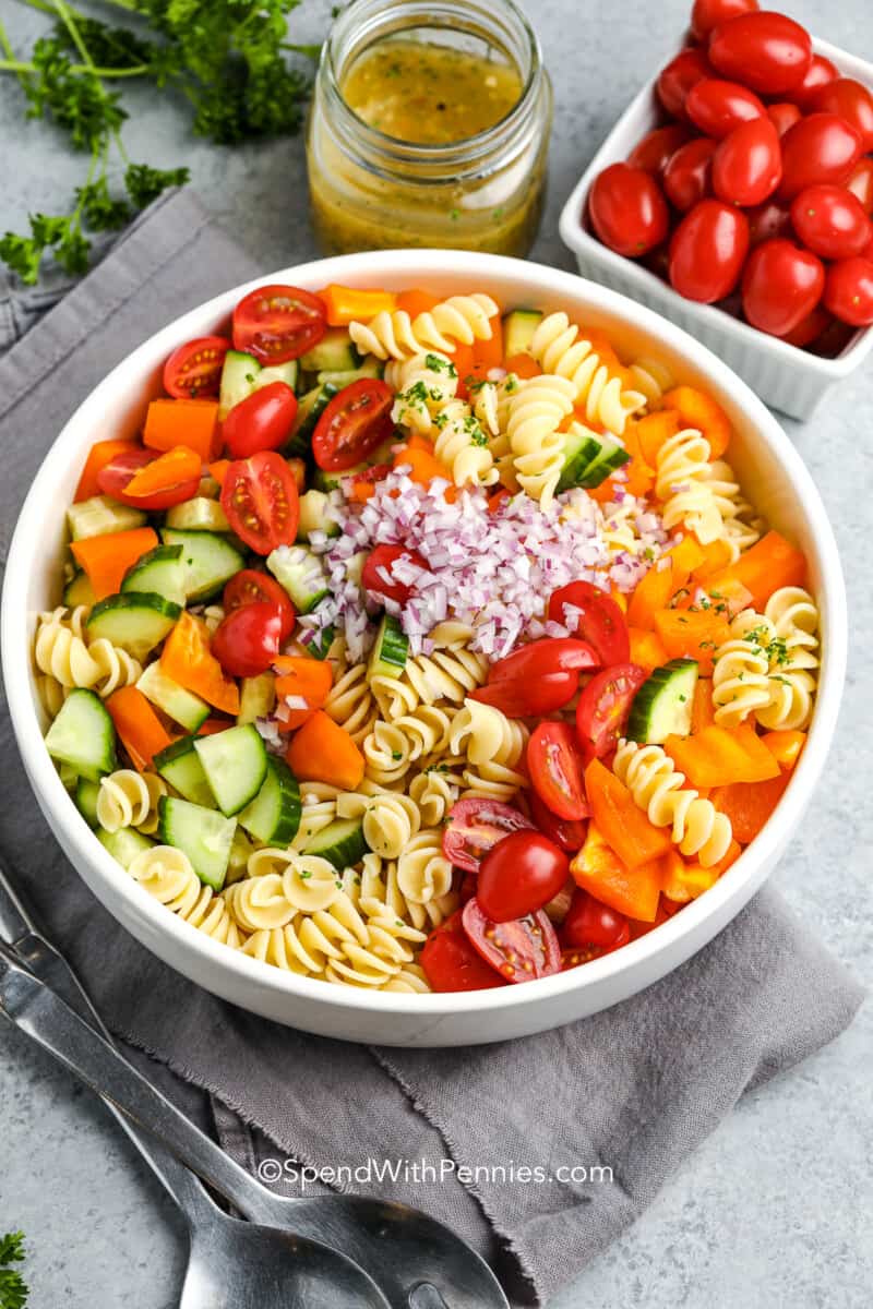 Ingredients for an easy pasta salad in a white serving bowl