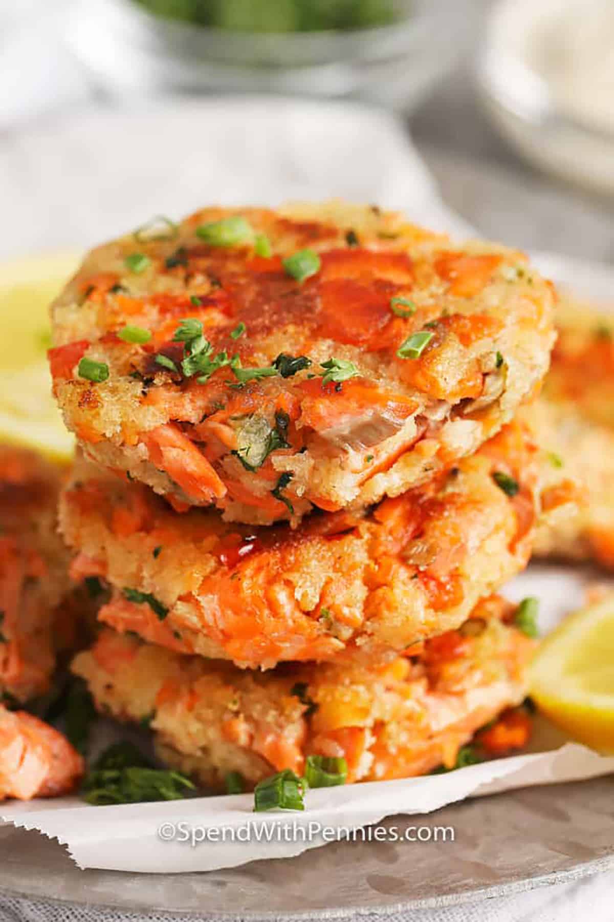 This simple salmon croquette recipe is delicious whether baked or fried! Made with salmon, mayonnaise, and panko they are shaped into patties and cooked until golden brown. Serve as an appetizer at your next party or as an easy lunch with a simple side salad. #spendwithpennies stack of Salmon Croquettes