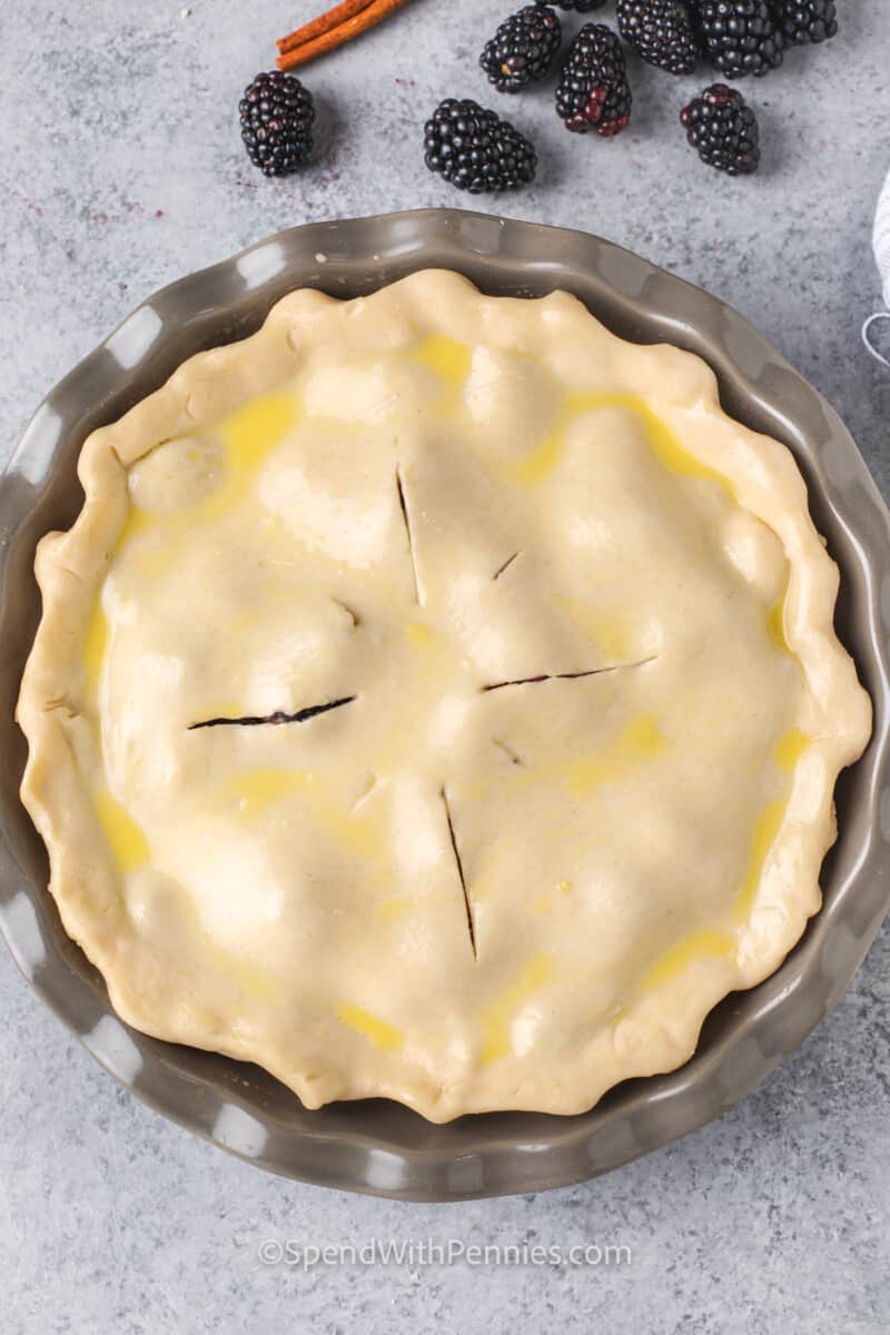 It will be hard to turn away that extra piece of dessert with this blackberry pie recipe. The pie in this recipe is made with a store-bought crust, but a crust from scratch would work also. Fill it with sweetened blackberries and then top it with another crust. So easy, so sweet, and oh so good! #blackberrypie #blackberrypierecipe #berrypie #spendwithpennies Blackberry Pie before baking