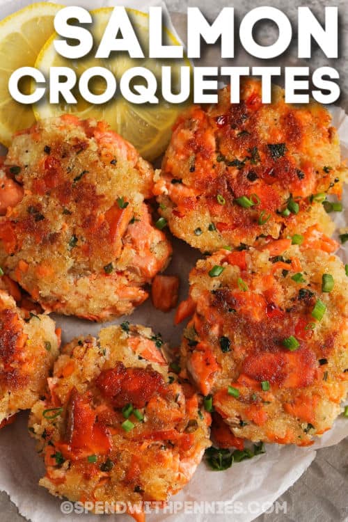 Salmon Croquettes are a delicious combination of salmon, mayo, panko, lemon juice, and herbs. They are then shaped into patties and baked or pan-fried until golden brown! Perfectly crispy and flavorful they are the perfect appetizer or light lunch when served with your favorite side salad. #spendwithpennies #salmoncroquettes #baked #easy cooked Salmon Croquettes on a plate with a title