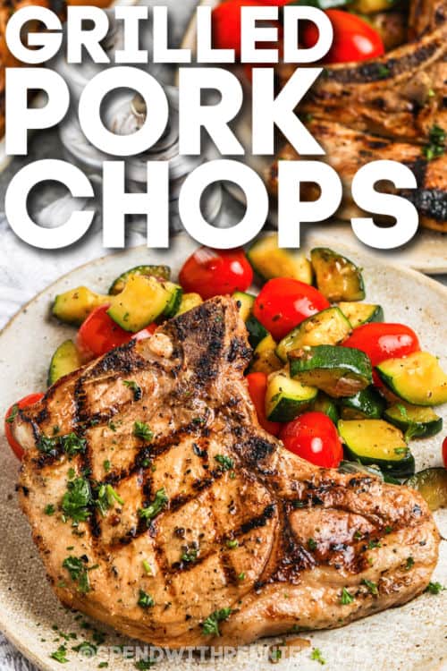 It doesn't take long to cook this easy recipe for grilled pork chops. Tender and juicy boneless loin chops are hot off the grill in no time, ready for serving with all your favorite summer side dishes. Try the tasty marinade, and enjoy all the flavors of summer grilling! #grilledporkchops #boneless #bestgrilledporkchopsrecipe #spendwithpennies cooked Grilled Pork Chops on a plate with vegetables and a title