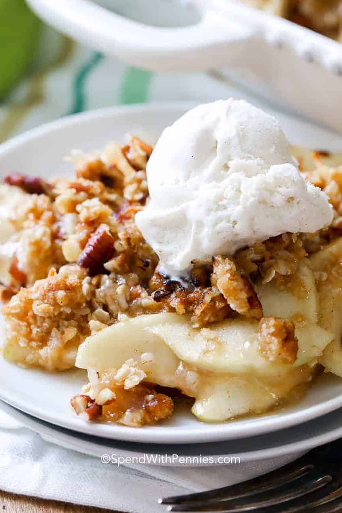 Apple Crisp is simple, homemade comfort food goodness in one delicious bite! The aroma of it baking makes you crave that combination of sweet and tart apple goodness! #spendwithpennies #applecrisp #fruitcrisp #withapples slice of Apple Crisp with ice cream