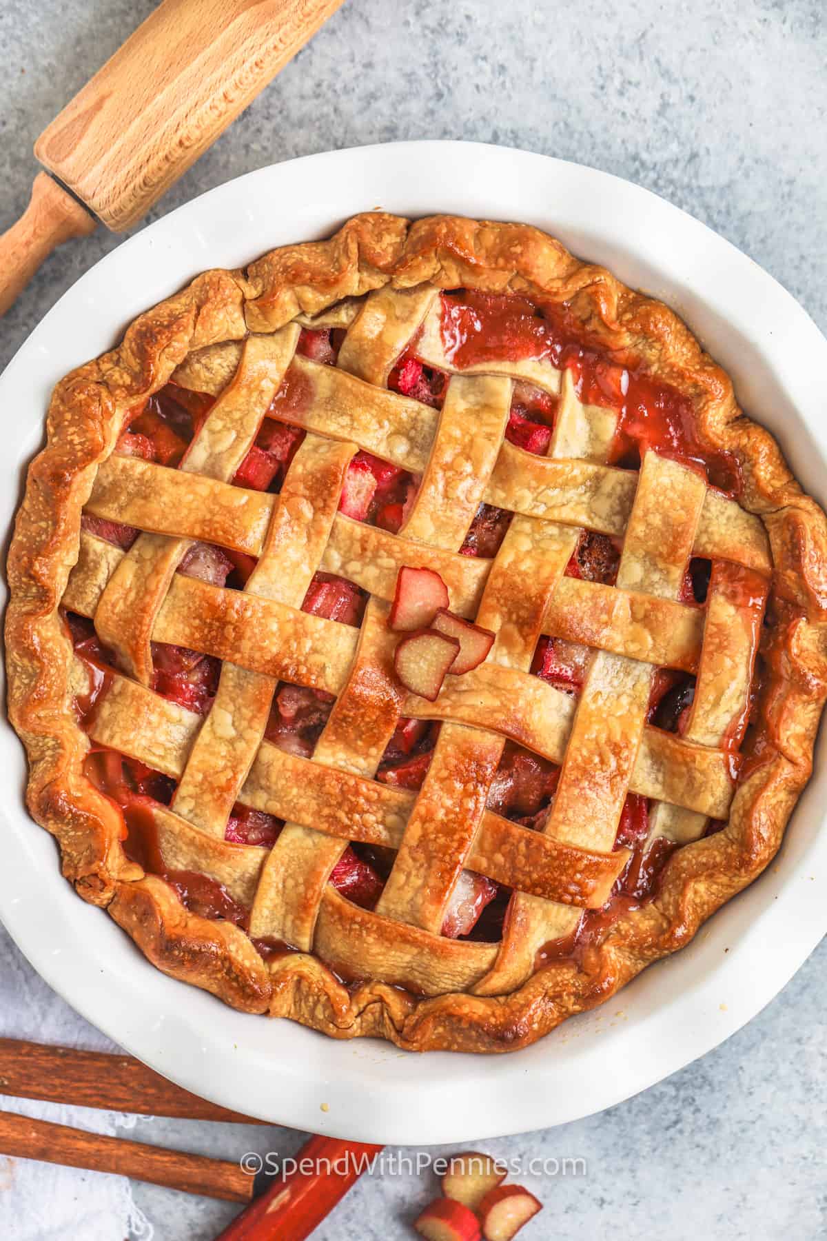 Rhubarb pie is a sweet and tart dessert that is so hard to resist. In this recipe, pie pastry is topped with some homemade rhubarb pie filling and then topped again with another circle of pie pastry. Then it's baked in the oven until the crust is brown and golden. Top this delightful pie with some strawberry sauce or vanilla ice cream. #rhubarbpie #spendwithpennies #easyrecipe #bestrhubarbpierecipe cooked Rhubarb Pie in the dish